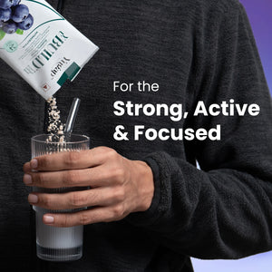Man pouring blueberry collagen skin supplement protein powder into glass of milk for strong, active, and focused lifestyle.