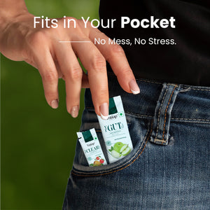 Hand placing Yugap Yugut apple and Yuclear kiwi strawberry wellness sachets into denim jeans pocket, emphasizing portable, mess-free health supplements for on-the-go convenience on natural outdoor background